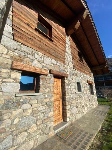 a stone building with a wooden door and windows at Casa degli iris in Quart