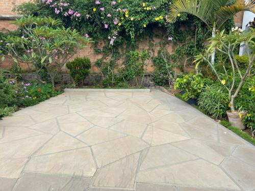 a stone walkway in a garden with flowers and plants at Appart Cozy Ivandry dans villa in Antananarivo