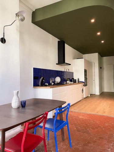 une cuisine avec une table en bois et des chaises bleues dans l'établissement L'appart Azur, 5 pers Joliette, à Marseille