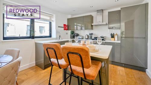 a kitchen with a table and chairs and a kitchen with a counter at QUALITY SERVICED APARTMENTS IN CAMBERLEY TOWN CENTRE, FREE WiFi, PERFECT FOR BUSINESS STAYS, FAMILIES, RELOCATIONS, EXTENDED STAYS, AND EMERGENCY ACCOMMODATION by REDWOOD STAYS in Camberley