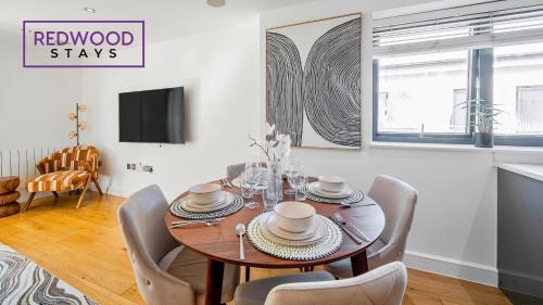 a dining room with a table and chairs at QUALITY SERVICED APARTMENTS IN CAMBERLEY TOWN CENTRE, FREE WiFi, PERFECT FOR BUSINESS STAYS, FAMILIES, RELOCATIONS, EXTENDED STAYS, AND EMERGENCY ACCOMMODATION by REDWOOD STAYS in Camberley