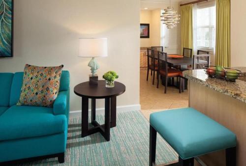 a living room with a blue couch and a table at Beautiful resort 1BD condo with amazing resort amenities pool, kiddie pool, and more in Nassau