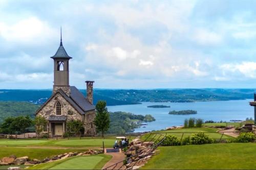 a church on top of a hill with a lake at Roark A202, Indoor & Outdoor Pools, Fitness Center in Branson