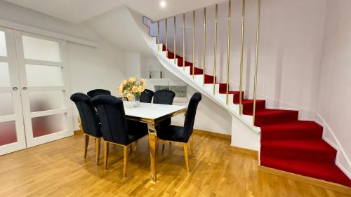 a dining room with a table and chairs and a staircase at Villa Parc - Parking privé - Disneyland 7min - 8 P in Serris