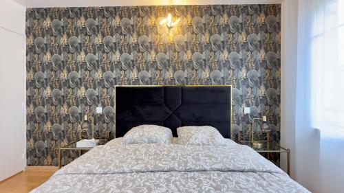 a bedroom with a bed with a black headboard at Villa Parc - Parking privé - Disneyland 7min - 8 P in Serris