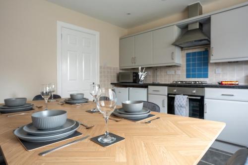 a kitchen with a wooden table with wine glasses on it at The Rise Retreat in Livingston