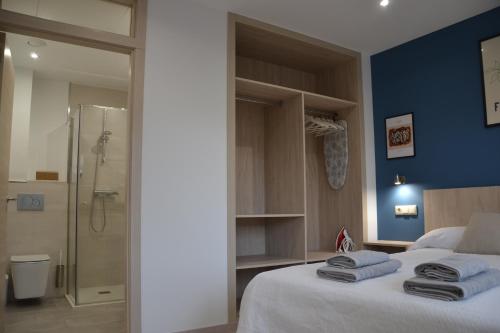 a bedroom with a king sized bed and a shower at Avío Apartamentos in Santiago de Compostela