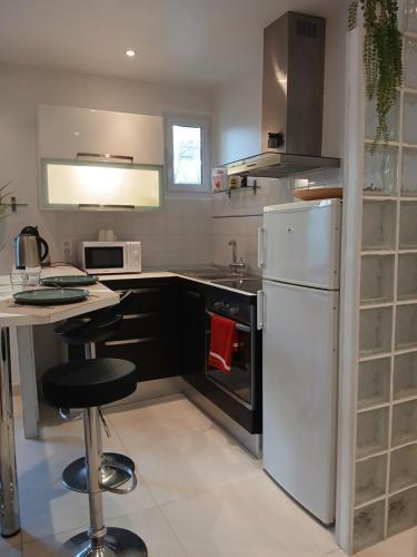 une cuisine avec un réfrigérateur blanc et un comptoir dans l'établissement Appartement centre Antibes bd Albert 1er, à Antibes