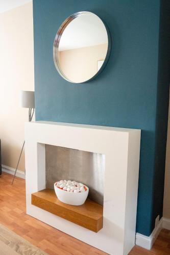 a mirror over a fireplace with a bowl of balls at Marina House in Bathgate