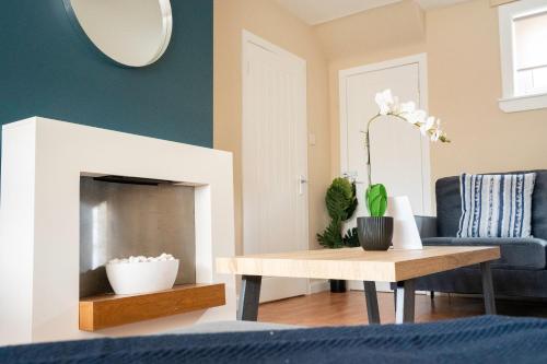 a living room with a fireplace and a table at Marina House in Bathgate