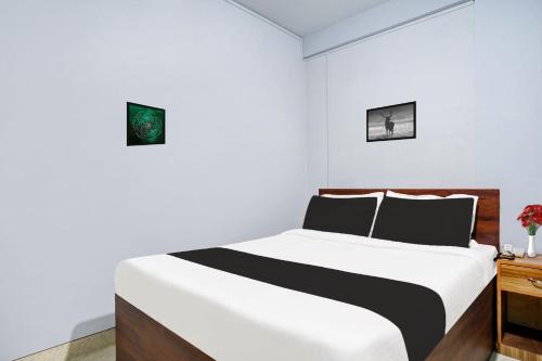 西隆Super Hotel O Lapalang Shillong的一间白色卧室,配有床和床头柜