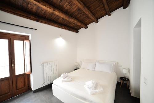 a white bedroom with a white bed and a window at Palermo Inn Boutique Hotel in Palermo