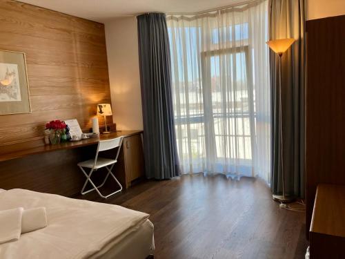 a hotel room with a bed and a desk and a window at Haus Alexander in Frechen