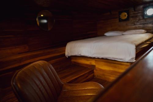 a bedroom with a bed and a desk with a chair at Floating Hotel SALTWATER COWBOYS in Kuta