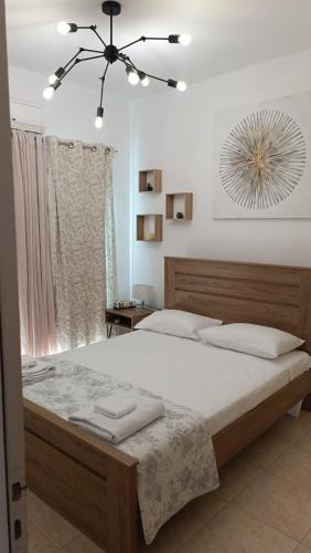 a bedroom with a large bed and a chandelier at Andromeda Hideaway in Polis Chrysochous