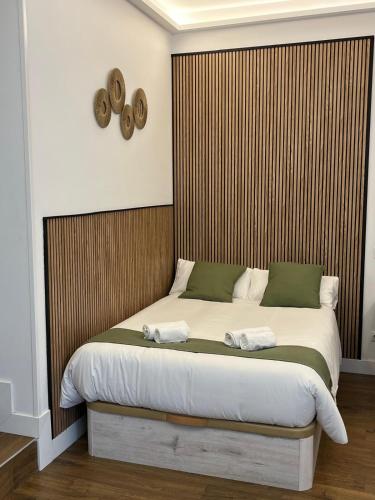 a bedroom with a large bed with a wooden headboard at Retiro Home in Madrid