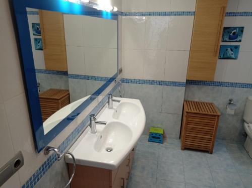 a bathroom with a sink and a mirror and a toilet at Los Iris Solo Familias Serviplaya in Playa de Gandia