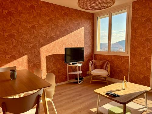 un salon avec une télévision, une table et des chaises dans l'établissement Appartement 3 chambres avec vue et parking, à Besançon