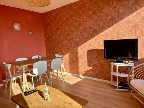 un salon avec une table à manger et une télévision dans l'établissement Appartement 3 chambres avec vue et parking, à Besançon