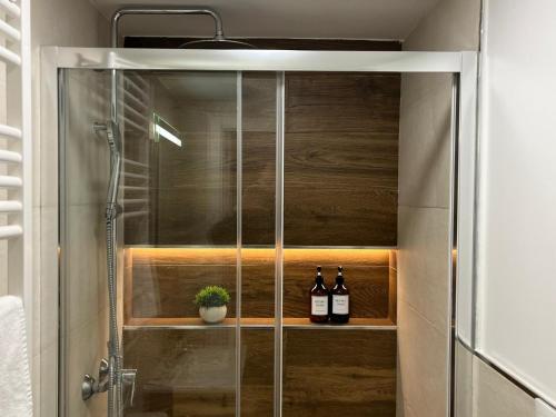 una cabina de ducha con dos botellas de vino en Retiro Home, en Madrid