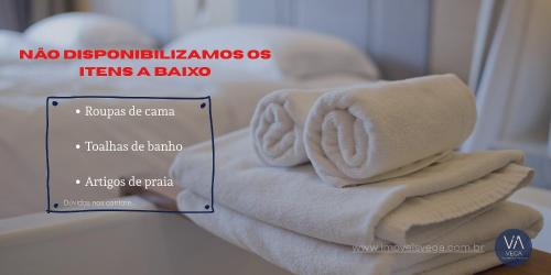 a pile of towels sitting on top of a bed at 201- Apartamento Bombas com vista lateral do mar in Bombas