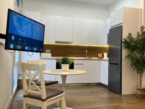 una cocina con una mesa con un monitor de ordenador. en Retiro Home, en Madrid