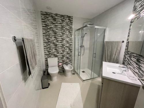 a bathroom with a shower and a toilet and a sink at Casa da Portelinha in Paredes de Coura