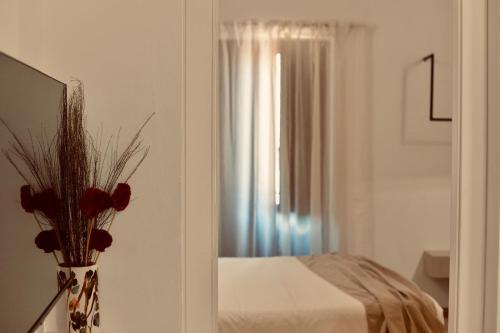 a room with a vase with red flowers in it at Palermo Inn Boutique Hotel in Palermo
