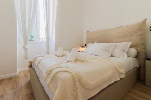 une chambre blanche avec un grand lit avec des oreillers blancs dans l'établissement Fancy 3BR Duplex Near Nice Port & Old Town | By Airnest, à Nice
