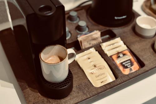a coffee maker and a cup of coffee on a counter at Palermo Inn Boutique Hotel in Palermo