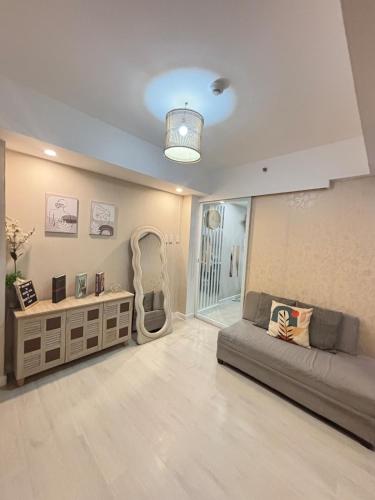 a living room with a couch and a chair at 1-BR Condo with 4 BEDS, DINING, Karaoke,NETFLIX,YTpremium,GAMES,WIFI,25TH fLoor - Sunrise & Sunset CITY&POOL view , wrap-around BALCONY in San Fernando