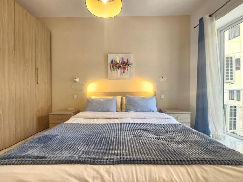 a bedroom with a large bed with a blue comforter at Pepprina in St. Paul's Bay