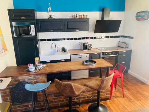 une cuisine avec une table, des chaises et un évier dans l'établissement Villa Fenouil, à Binic