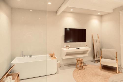 a bathroom with a tub and a tv on the wall at Palermo Inn Boutique Hotel in Palermo