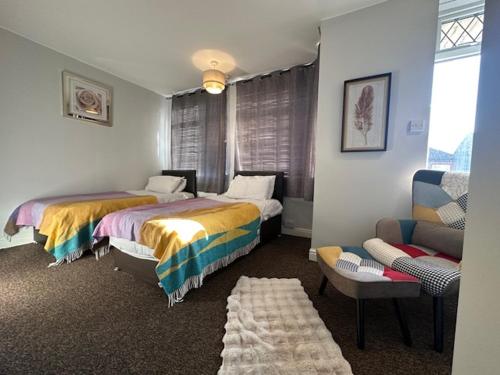 a hotel room with two beds and a couch at Chanterlands House in Hull