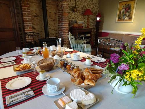 une table avec du pain et des croissants dessus dans l'établissement Le Clos Saint-Gilles, à Ardevon