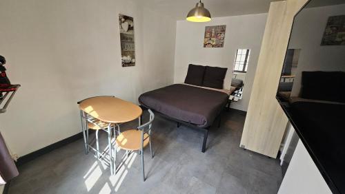 une petite pièce avec un lit, une table et des chaises dans l'établissement Le Carrel, à Rouen