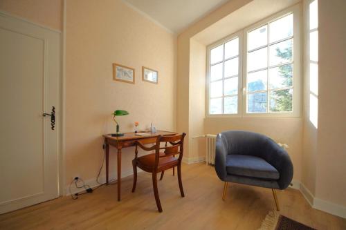 Cette chambre comprend un bureau, une chaise, une table et une fenêtre. dans l'établissement Au Ptit Bonheur du Lot, centre-ville, calme, vue, jardin, à Espalion