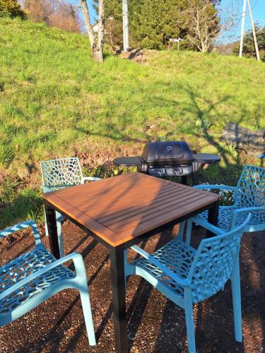 a picnic table with two chairs and a grill at Joy's Ferienwohnung in Lütschenbach