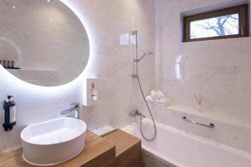 a white bathroom with a sink and a shower at Vadkert Major in Sárvár