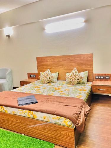 a bedroom with a large bed with a wooden headboard at SkyNest in Dehradun