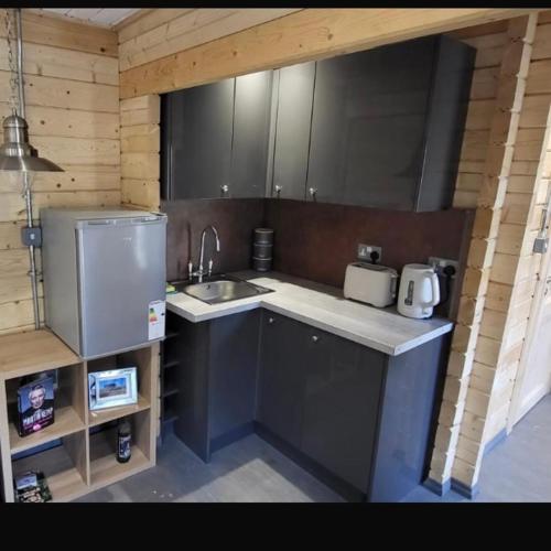 a small kitchen with a sink and a refrigerator at Sea La Vie in Perranporth