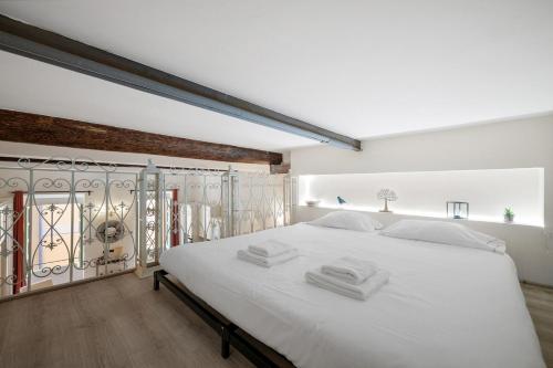 une chambre avec un grand lit blanc avec des draps blancs dans l'établissement Évasion à Menton, vieille ville, à Menton