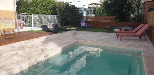 - une piscine dans un jardin avec des chaises et une table dans l'établissement Spacieux T3 avec piscine, à Digne-Les-Bains