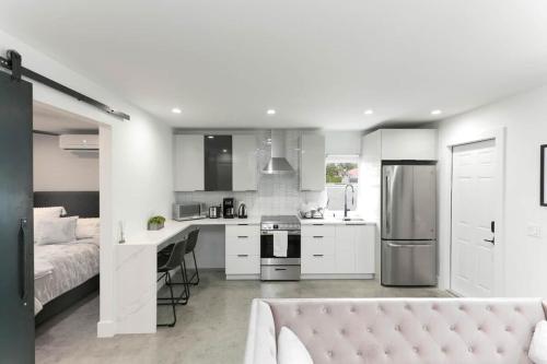 a white kitchen with a bed and a kitchen with a sink at 1BD 1BA-Black&White ArtBNB Cottage-Antique Row WPB in West Palm Beach