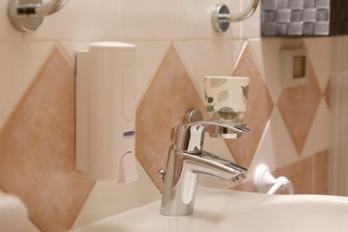 a bathroom with a sink and a faucet at Hotel Primavera in Peschiera del Garda