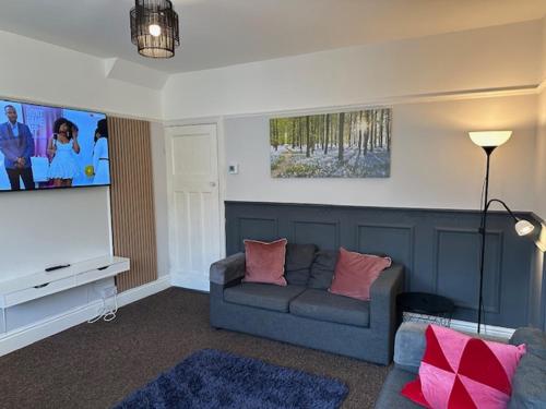 a living room with a couch and a flat screen tv at Chanterlands House in Hull