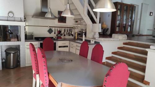 une cuisine avec une table et des chaises rouges dans l'établissement Ocre i Blau, à Canet