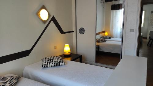 - une chambre avec un lit, une lampe et un miroir dans l'établissement Ocre i Blau, à Canet