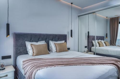a bedroom with a large bed and a mirror at Jasmina Villas in Agios Nikolaos